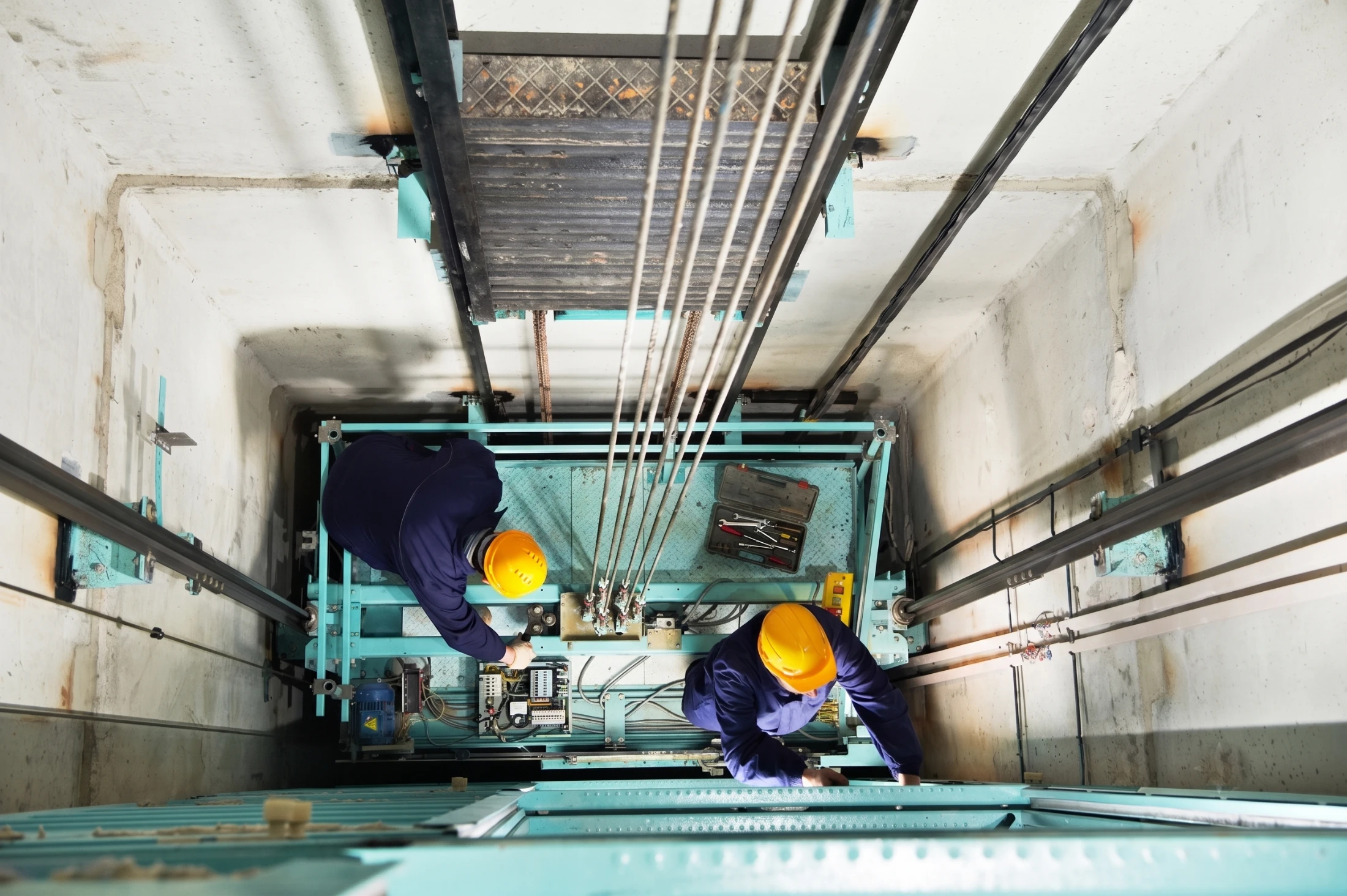 Técnicos instalando un ascensor dentro del hueco